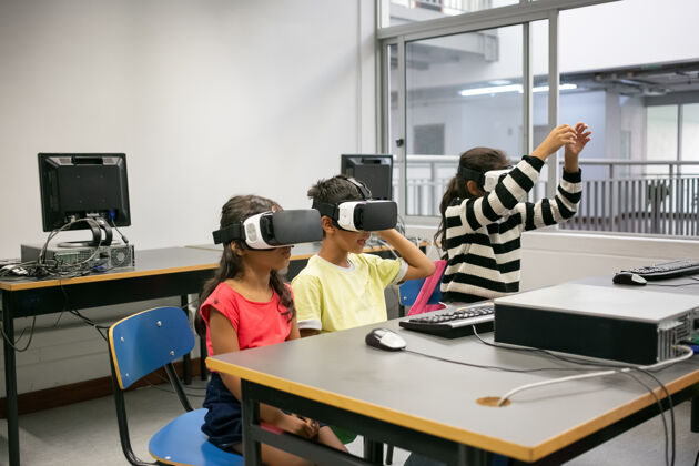 课可爱的多民族孩子学习使用虚拟现实眼镜可爱人黑发