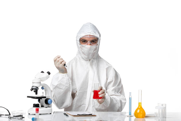 专业正面图：男医生穿着防护服 戴着面罩 因为科维德在一个空白处工作实验室外套病毒化学