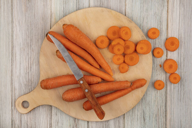食物顶视图减肥友好的食物胡萝卜在一个木制的厨房板与刀切碎胡萝卜在灰色的木制背景刀灰色胡萝卜