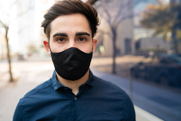 户外站在街上戴着防护面具的年轻人的画像休闲城市流行