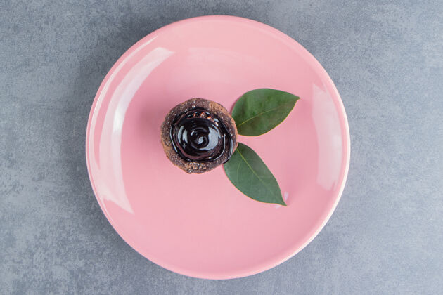食物粉红色盘子上有叶子的巧克力蛋糕碎片美味美味