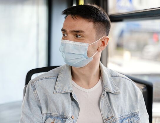 感染预防年轻人戴着口罩坐公交车男孩旅行坐姿