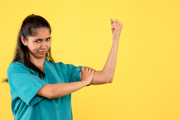 女人前视图穿着制服的女医生展示手臂肌肉站立肖像人女医生