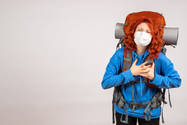 旅行戴着面具背着背包的女游客的正面图肖像女游客情感