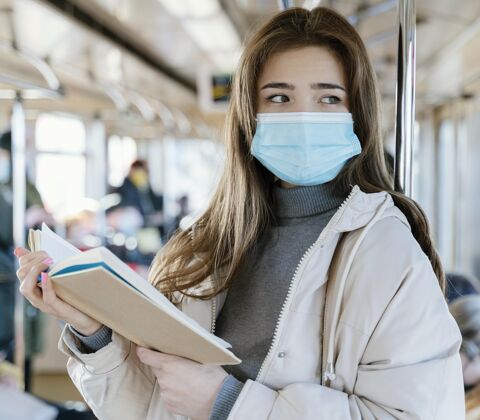 防护坐地铁读书的年轻女子公共服务地铁旅游