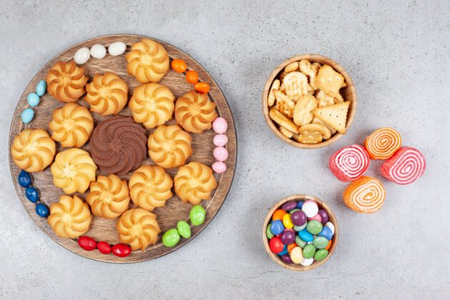 Marmelade饼干和糖果放在木板和木碗里 大理石背景上有大理石花纹高质量照片曲奇饼糖尿病糖果