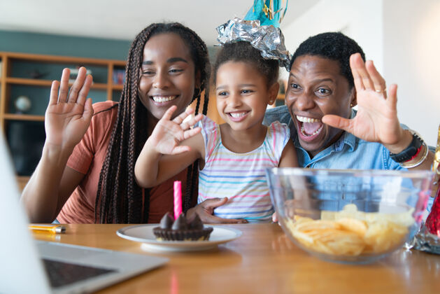 视频会议一家人在家里通过视频电话庆祝生日的照片享受互联网社交距离