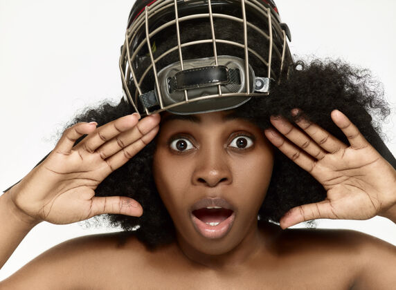 面部女曲棍球运动员特写头盔和面具在白墙上非洲裔美国人模型球员游戏棍棒