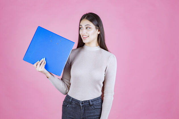 女性女孩拿着一个蓝色的项目文件夹 看起来很成功和快乐休闲报告幸运