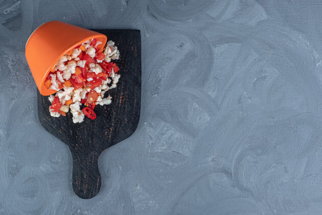 碗一碗花椰菜和胡椒沙拉洒在大理石背景的木板上沙拉美味美味