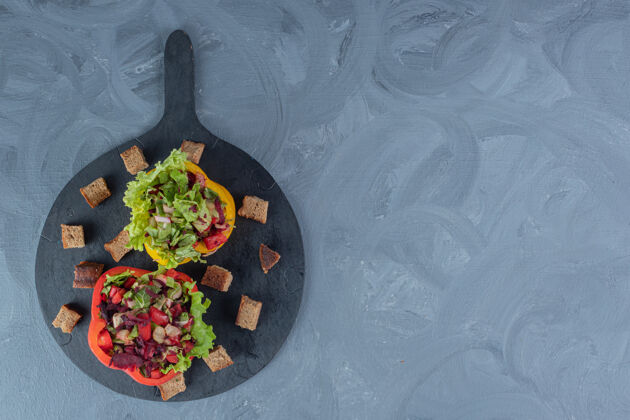 莴苣把沙拉分成甜椒片 放在大理石背景的托盘上美味背景干皮