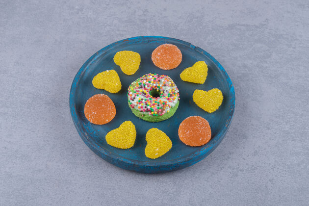 甜点蓝色的盘子和一个小甜甜圈和各种大理石表面的marmelades`烘焙食品拼盘糕点