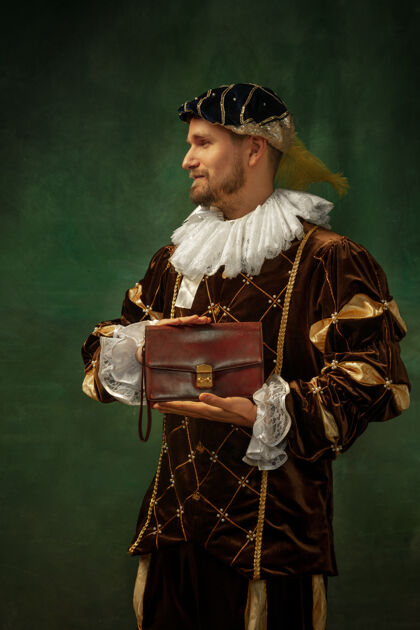 城堡商人的包中世纪年轻人穿着古董衣服站在黑暗的背景上的肖像作为公爵 王子 皇室的人的男模时代 现代 时尚的比较概念比较古代中世纪