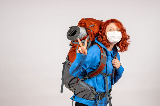 背包正面图女游客带着背包 戴着面具上山旅游面具徒步旅行人