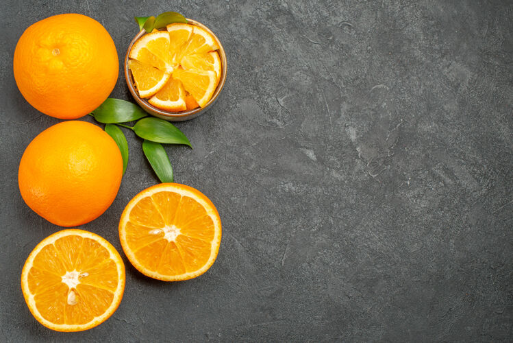 水果黑色桌子上一套黄色的整片橙子和切碎的橙子的水平视图可食用水果甜橙新鲜