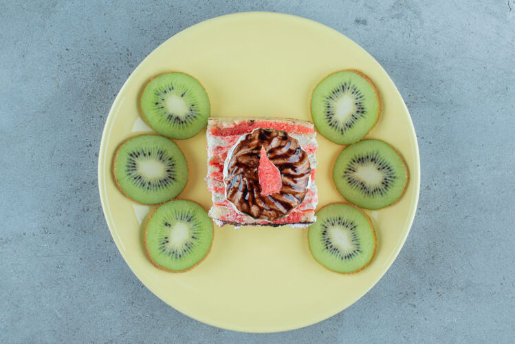 切片绿色盘子上有几片猕猴桃的甜蛋糕烘焙小吃果酱