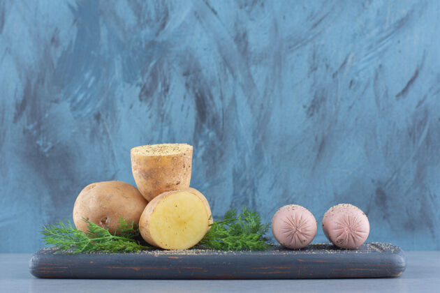 特写一堆土豆躺在黑木板上沙拉新鲜健康