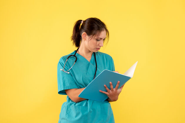 衬衫正面图黄色背景下穿着医用衬衫的女医生拿着分析医疗护士持有