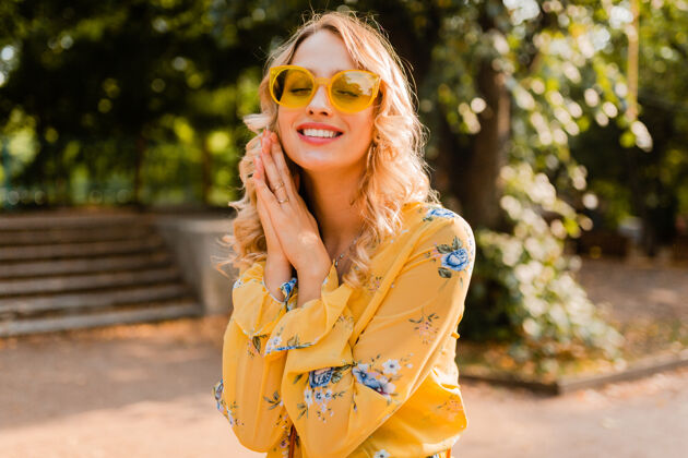 欢呼美丽的金发时尚微笑的女人穿着黄色衬衫戴着太阳镜的肖像头发太阳镜光
