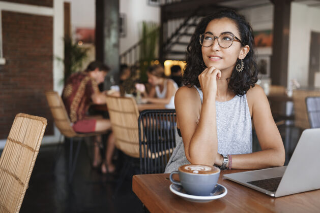 工作垂直拍摄温柔放松的都市女人戴着眼镜享受独自坐在咖啡馆的时刻大学咖啡馆享受