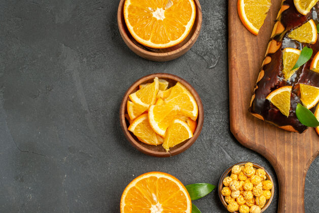 果汁在黑桌子上的新鲜橙子和软蛋糕上切半片的半张照片减肥甜橙切片