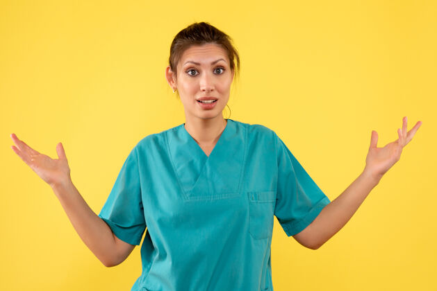 成人前视图黄色背景上穿着医用衬衫的女医生视图黄色护士