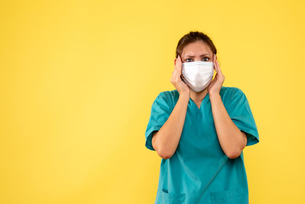 面具前视图黄色背景上穿着医用衬衫和面罩的女医生病毒医疗流行病
