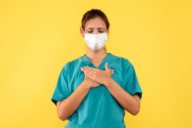 人正面图黄色背景上穿着医用衬衫和面罩的女医生流行牙套衬衫