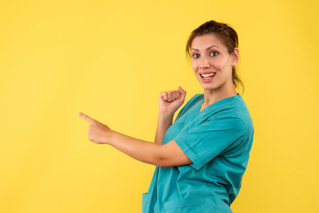 肖像正面图黄色书桌上穿着医用衬衫的女医生病毒医院医护人员健康疾病颜色微笑人护士