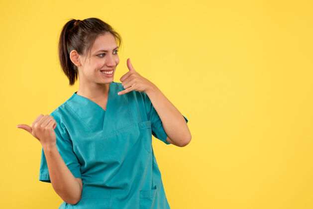 女医生前视图黄色背景上穿着医用衬衫的女医生人成人医疗