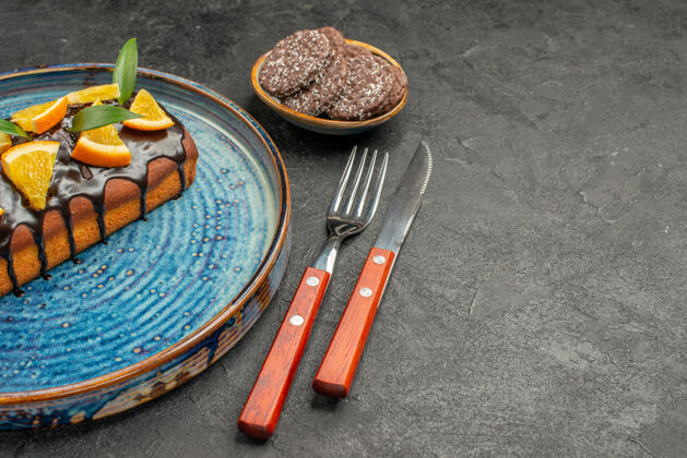 水平黑色桌子上的美味蛋糕和饼干用叉子和刀子的水平视图木材建筑工具
