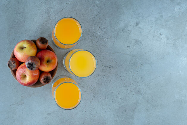 碗一个木制的苹果碗和一杯橙汁苹果食物水果