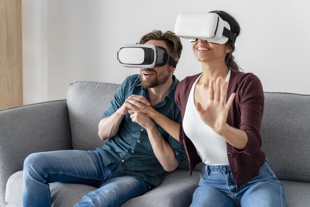 男人男人和女人在家里的沙发上玩虚拟现实耳机的乐趣虚拟现实耳机房子女人