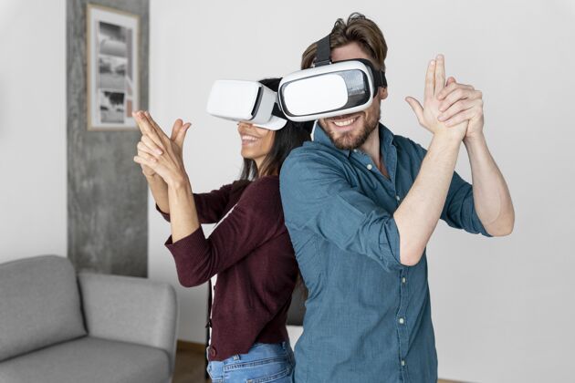 休闲男人和女人一起在家玩虚拟现实耳机虚拟现实虚拟现实眼镜女人