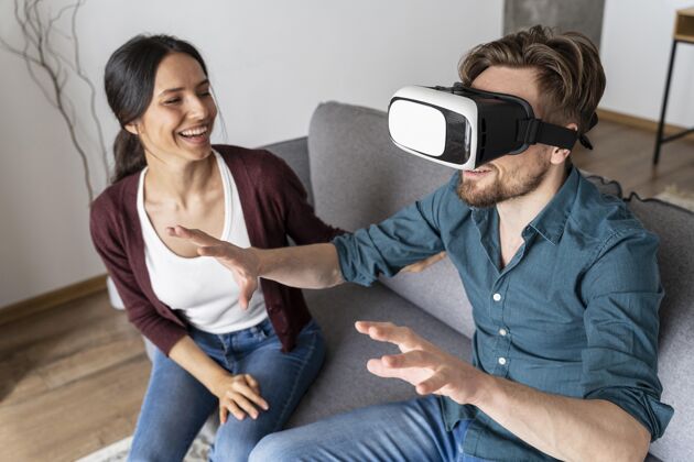 休闲男人在家里用虚拟现实耳机挨着女人虚拟现实虚拟现实虚拟现实眼镜