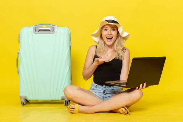 年轻前视图年轻女性用笔记本电脑在黄色的墙上女孩航行度假旅行太阳视野漂亮笔记本电脑
