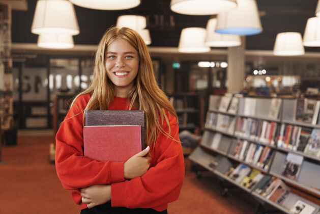 书店开朗的微笑 捧着书的读书妹 站在图书馆或书店里阅读室内大学
