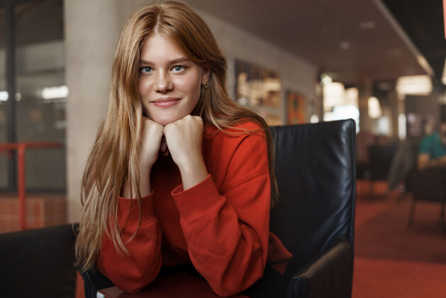 大学年轻漂亮的红发女学生的画像 坐在扶手椅上 靠在胳膊上微笑着休闲人聪明