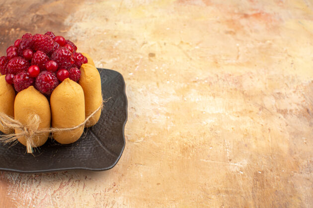 水果咖啡和茶时间的礼品蛋糕 在混色桌上的棕色托盘上放着覆盆子糖草莓食物