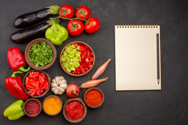 蔬菜顶视图新鲜蔬菜与绿色和不同调味料的灰色背景餐沙拉健康食品蔬菜调味品新鲜生的