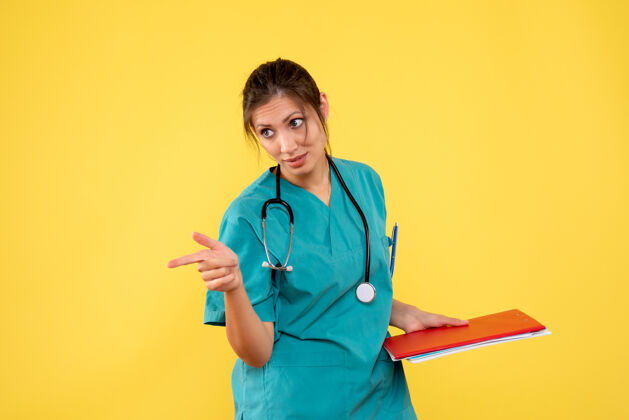 专业前视图穿着医用衬衫的女医生拿着黄色背景的笔记人药黄色