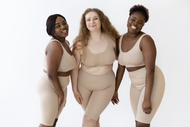 紧身衣三个自信的笑脸女人穿着塑身衣摆姿势女性身体女性授权女性