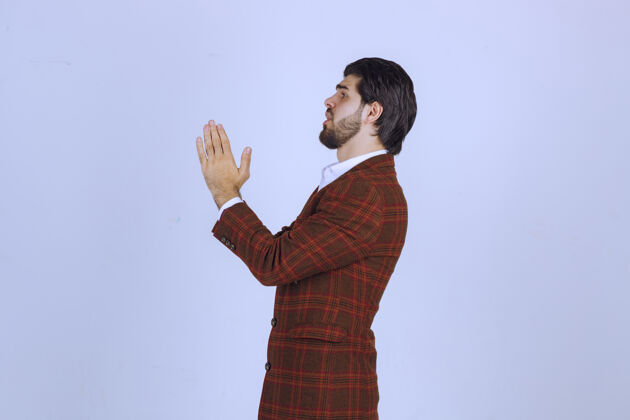 精神穿棕色外套的人双手合十祈祷年轻人年轻职员