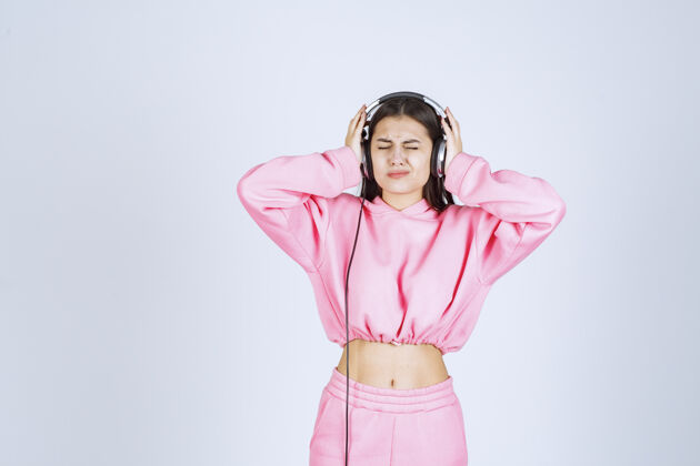 娱乐穿着粉色睡衣的女孩在听耳机 不喜欢音乐高质量的照片人体模特休闲姿势