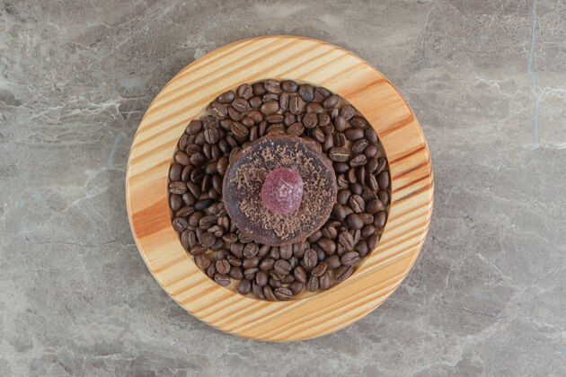 慕斯巧克力糖霜蛋糕和咖啡豆放在木盘上咖啡甜点热的