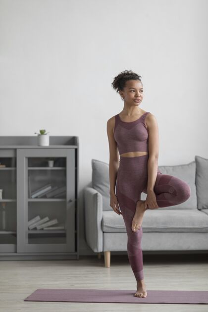 健康健身女士在家里用瑜伽垫做瑜伽人体生活方式房子