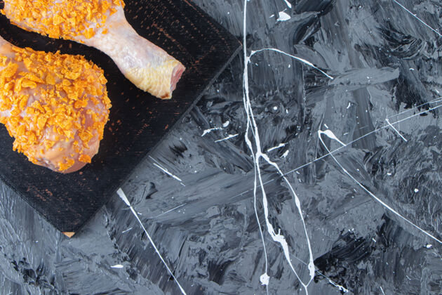 香料把腌好的鸡腿放在切菜板上 放在香料碗旁边 放在大理石背景上鸟生的饭
