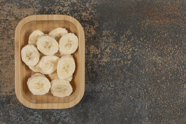 生把削皮的香蕉片放在木盘上营养果皮热带