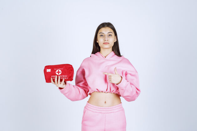 员工穿着粉色睡衣的女孩拿着一个红色的急救箱在宣传女人员工产品
