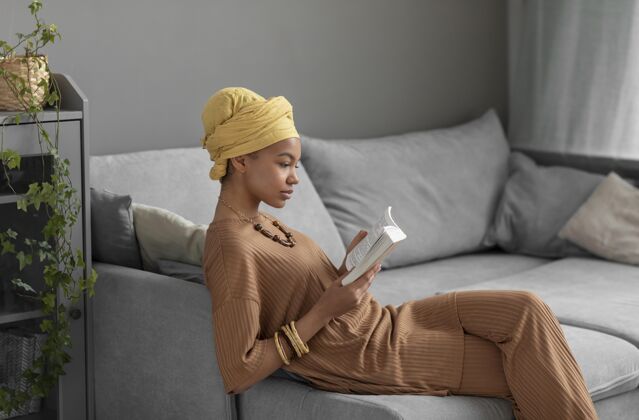 阿拉伯妇女放松的阿拉伯女人在家看书头巾文化学习
